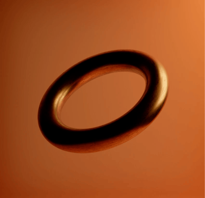 Rendering of a chrome torus floating in an orange studio background